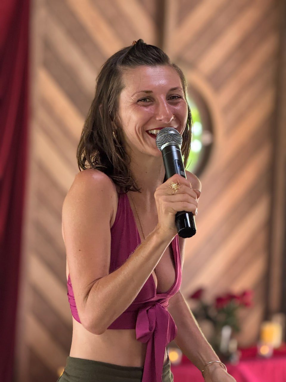 Charla smiling, microphone in hand, guiding a session in Bali